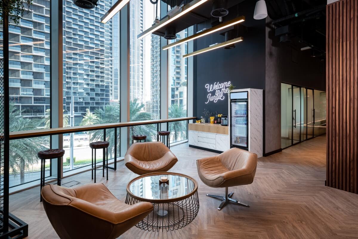 Roar Fitness Dubai reception lounge with modern design, leather armchairs, and city views